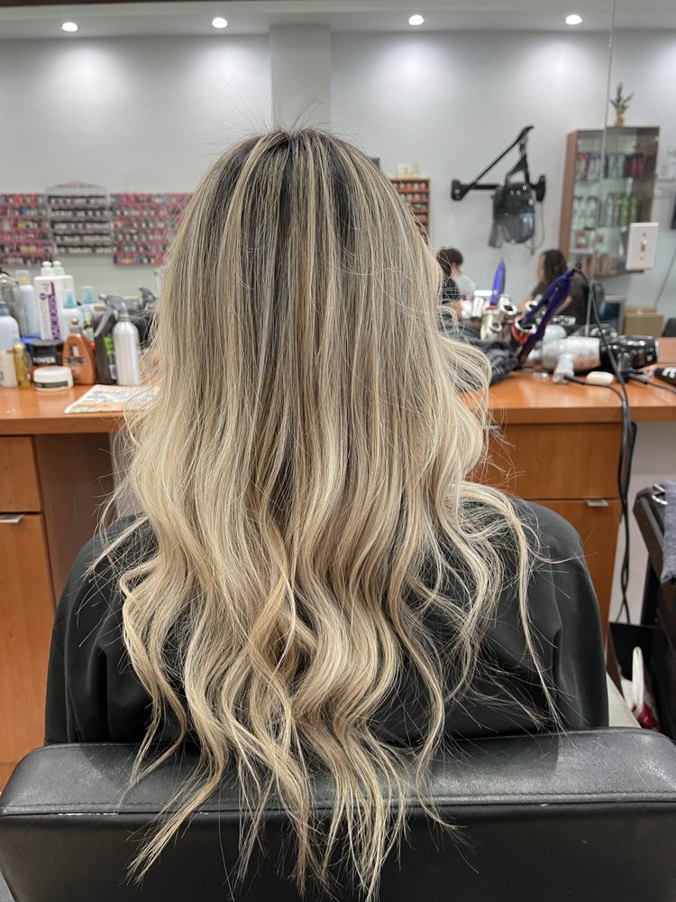 Long blonde balayage hair color, styled at Tiptop Hair Designs
